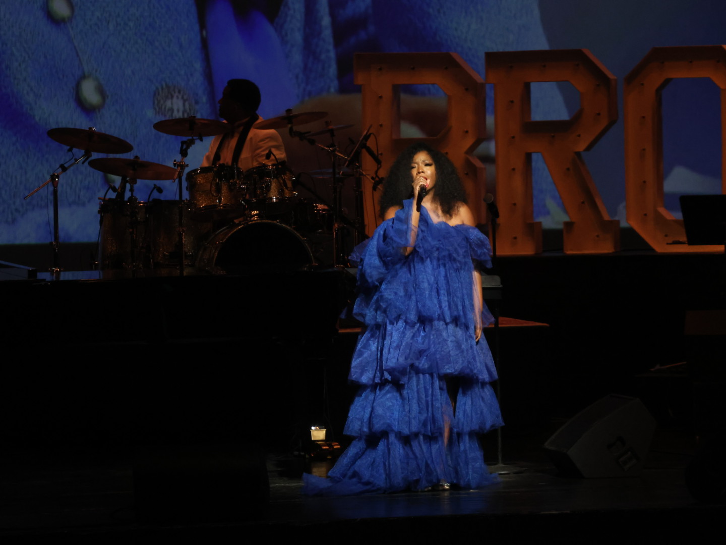 Ashley Támar performing in a blue gown at Broadway on the Hill
