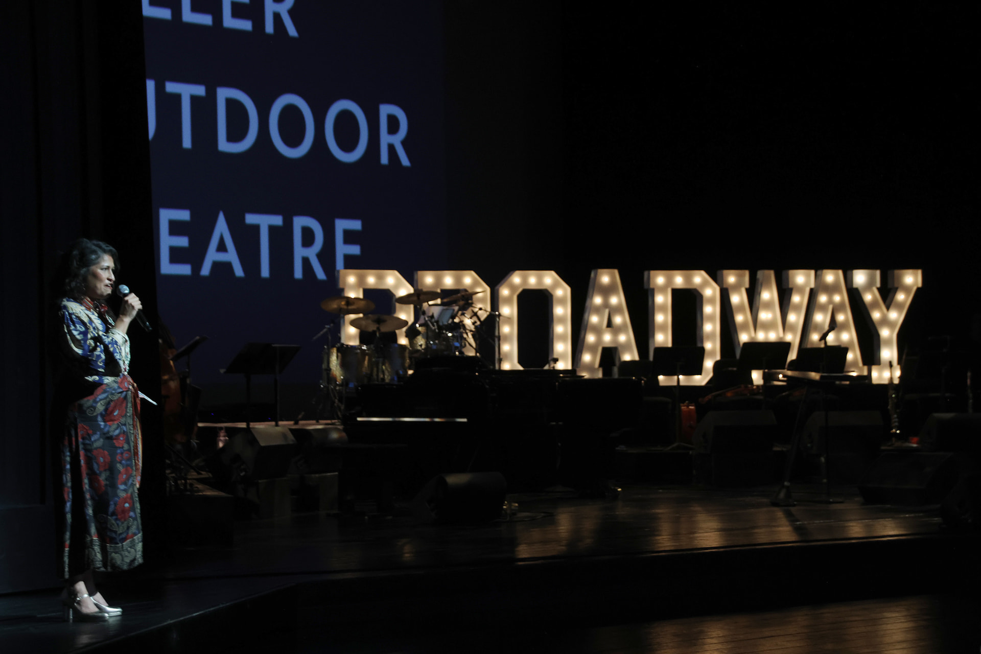 Speaker on stage at Miller Outdoor Theatre during Broadway on the Hill